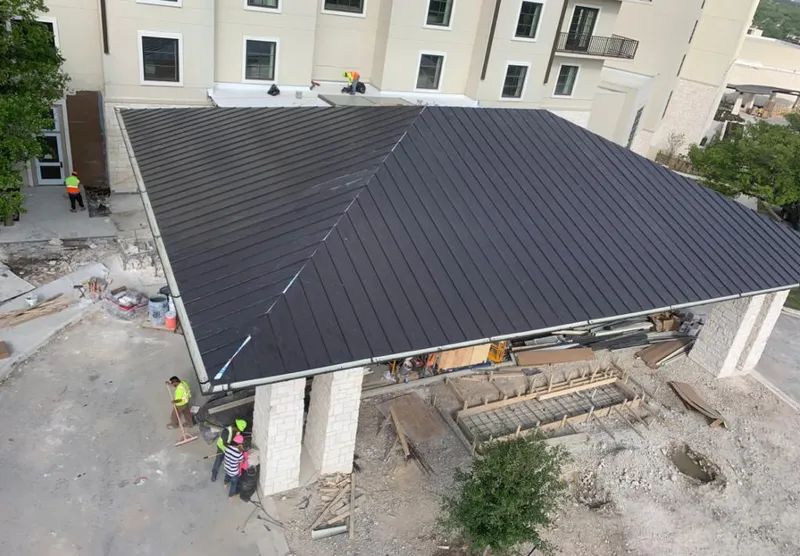 Metal roofing installation team working on a commercial building in Alexandria